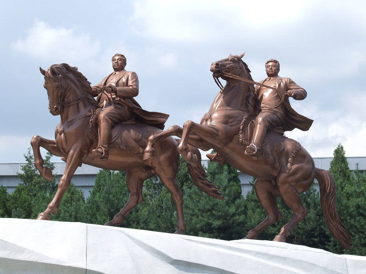 A grand statue located in Pyonyang of Kim Il Sung and Kim Jong Un riding steeds.
