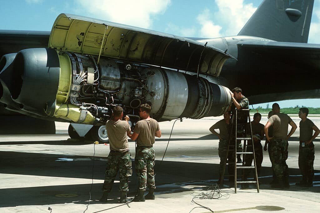 Ground crew members perform maintenance on an engine of a B-52G Stratofortress aircraft during Operation Desert Shield.