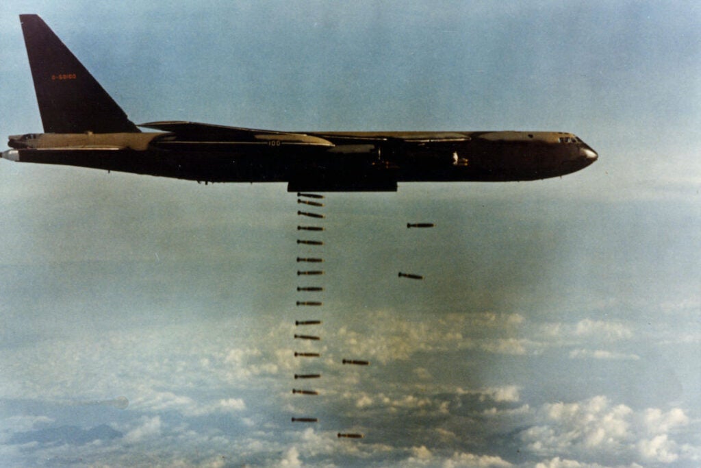 Boeing B-52D-65-BO (S/N 55-0100) in flight dropping bombs. (U.S. Air Force photo)