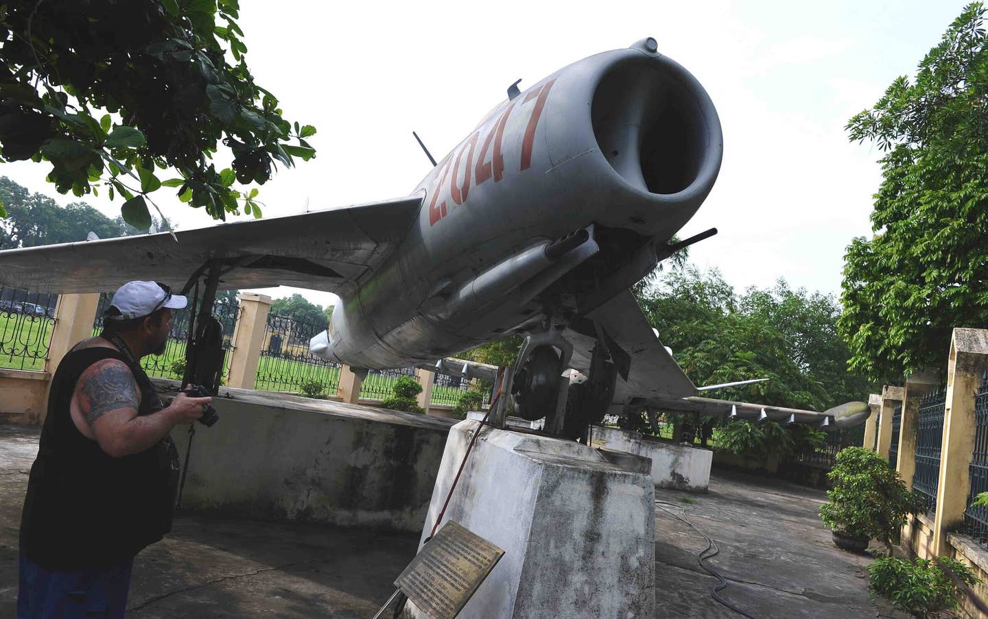 A foreign tourist looks at a Soviet-made MiG-17F jet used during the Vietnam War and now on display at the VPAF Museum in Hanoi. This aircraft, which was eventually credited with seven air-to-air kills, was configured as a fighter-bomber when flown by Nguyen Van Bay in an attack on the cruiser USS <em>Oklahoma City</em> on April 19, 1972. <em>HOANG DINH NAM/AFP/GettyImages</em>