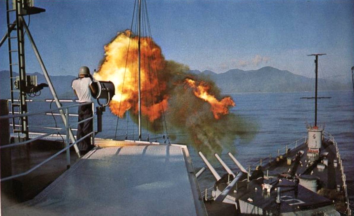 USS&nbsp;<em>Oklahoma City</em>&nbsp;firing its 152-mm guns during a gunfire support mission off Vietnam, in 1965 or 1966. <em>U.S. Navy</em>
