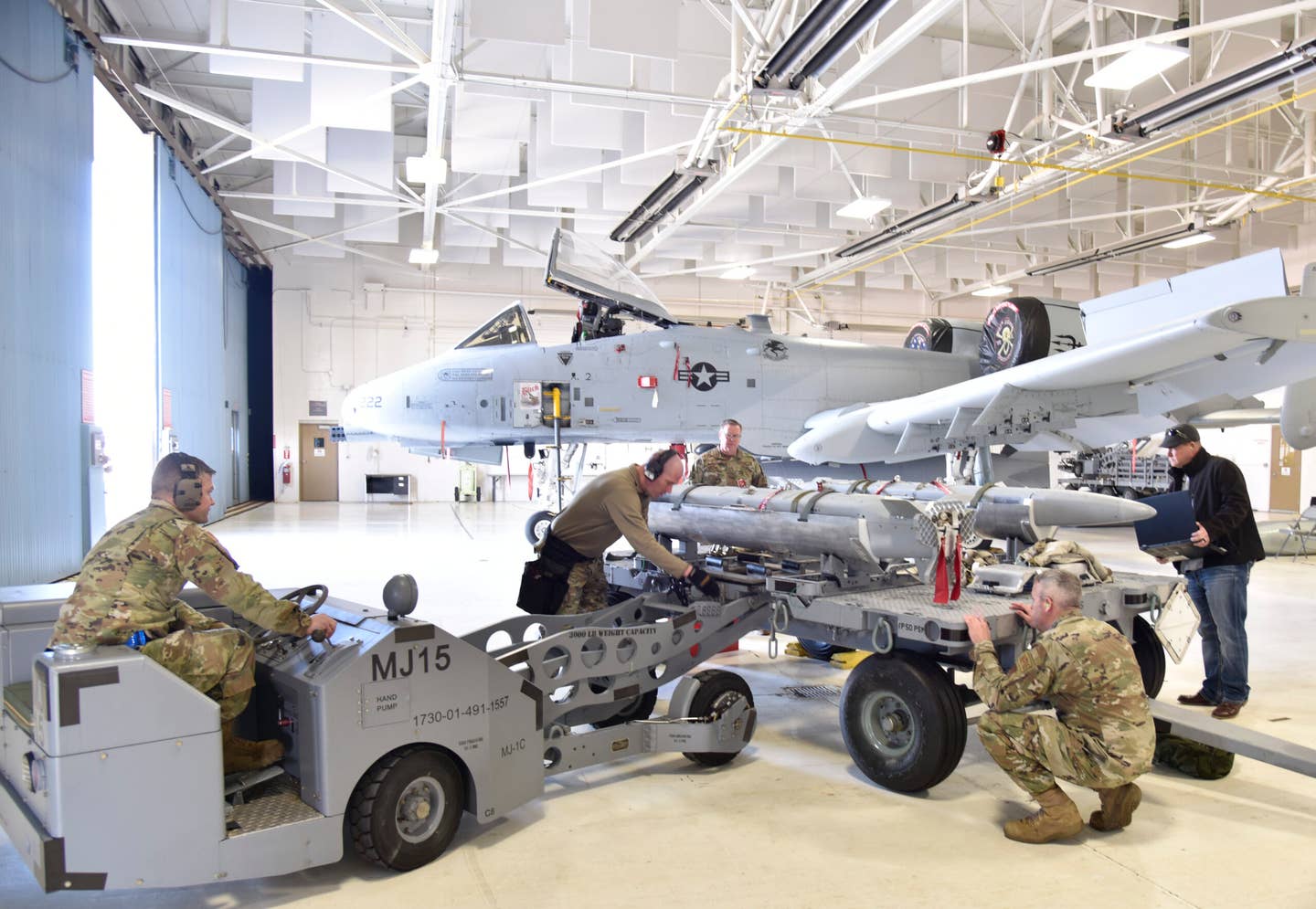Maintainers prepare to load Miniature Air-Launched Decoys, or MALDs, onto an A-10C at Volk Field Air National Guard Base, Wisconsin, in March 2022. <em>U.S. Air National Guard photo by Tech. Sgt. Samara Taylor</em>