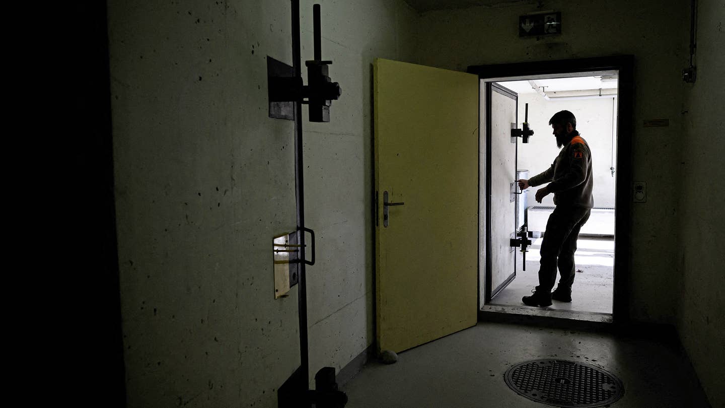 An officer of the Swiss Civil defence of the canton of Valais closes the door of a public concrete nuclear fallout shelter located in the village of Evionnaz, western Switzerland on March 28, 2022. - Russia's invasion of Ukraine has awakened long-slumbering anxiety interest in Switzerland in concrete nuclear fallout shelters built across the country during the Cold War, with spots available for every single resident. (Photo by Fabrice COFFRINI / AFP) (Photo by FABRICE COFFRINI/AFP via Getty Images)