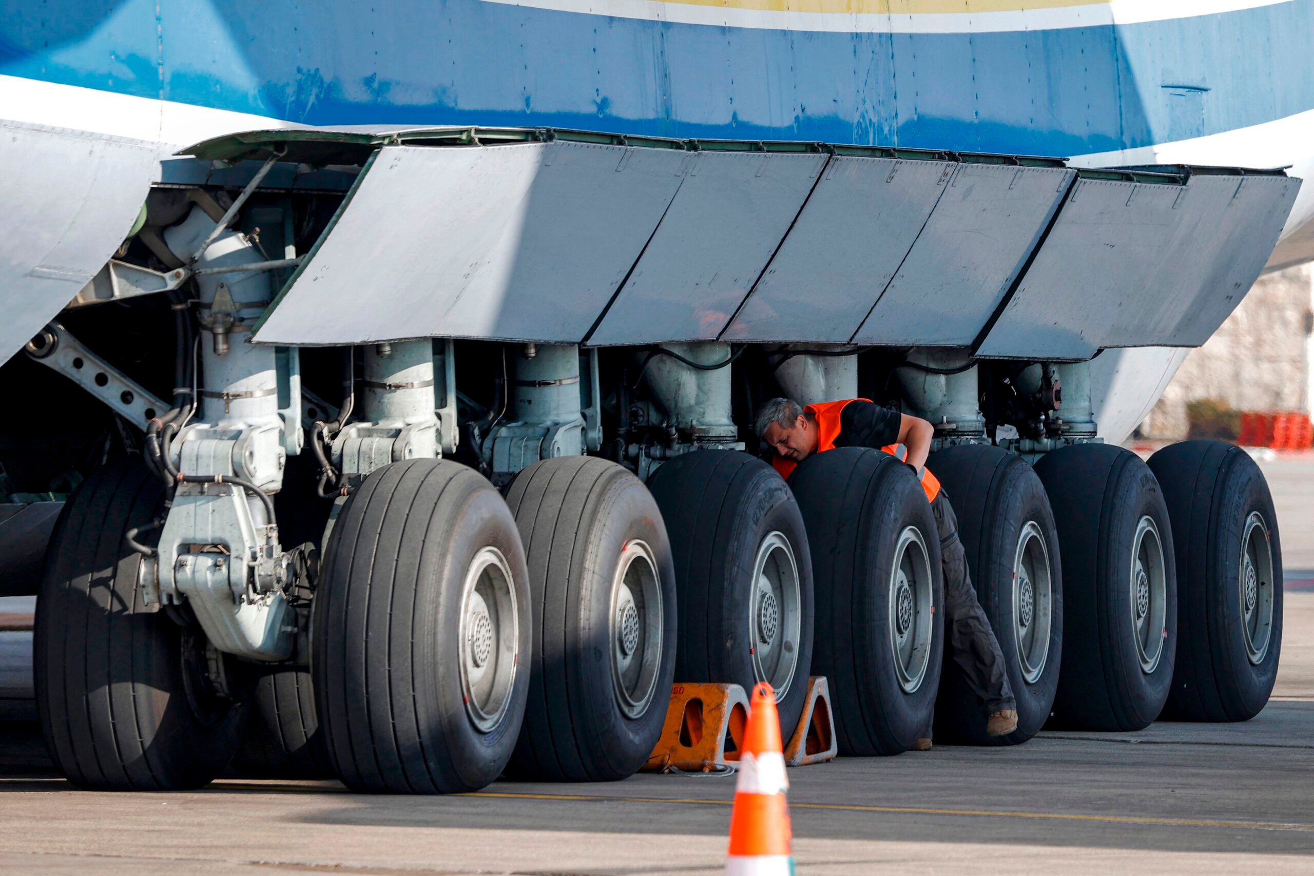 An airport technician checks on the landing gear of the Soviet-built Antonov Airlines Antonov An-225 Mriya strategic airlift cargo aircraft, the world's largest cargo plane, at Israel's Ben Gurion International Airport in Lod, east of Tel Aviv on August 3, 2020. - The aircraft arrived in Israel carrying US Oshkosh military vehicles, which will be fitted to be used Iron Dome systems purchased by the US military, as per an August 2019 agreement. (Photo by JACK GUEZ / AFP) (Photo by JACK GUEZ/AFP via Getty Images)