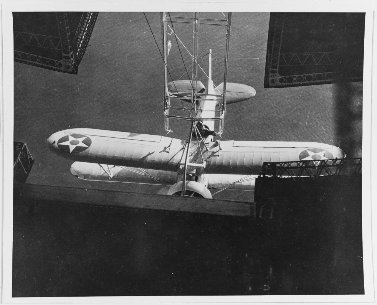 A remarkable photograph, showing the pilot of an XF9C-1 Sparrowhawk fighter reaching out to guide the trapeze of the airship USS <em>Akron</em> (ZRS-4), to ensure it fits tightly with the hook assembly on the upper wing of his plane. The photo was taken almost exactly 90  years ago — on May 3, 1932. <em>U.S. National Archives.</em>