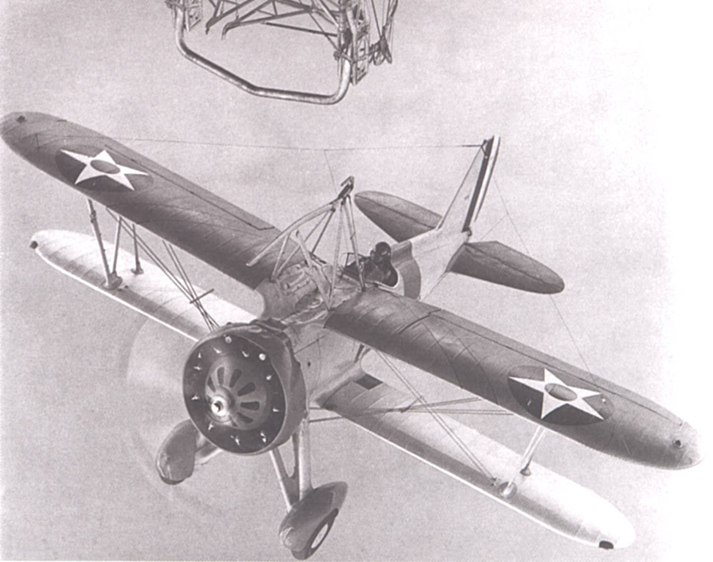 A dynamic view of an F9C-2 Sparrowhawk approaching the trapeze of&nbsp;USS <em>Macon</em>, circa 1932. U.S. Navy<br>
