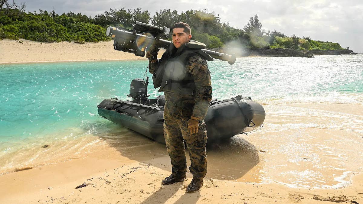 A Marine holding a Stinger missile launcher stands in front of a Combat Rubber Raiding Craft on Ukibaru Island off the coast of Okinawa during Exercise Hagatna Fury 21. <em>USMC</em>