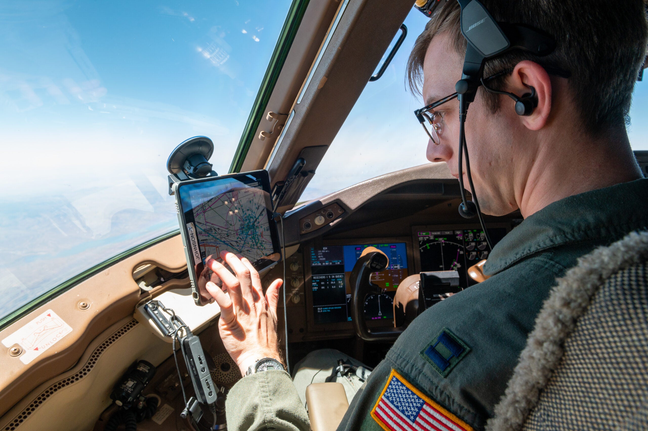 Captain Taylor Johnson, 349th Air Refueling Squadron instructor pilot, checks the flight path details May 5, 2022. Johnson is able to see live updates of weather, air traffic and flight plans using a Stratus puck. (U.S. Air Force photo by Airman Brenden Beezley)