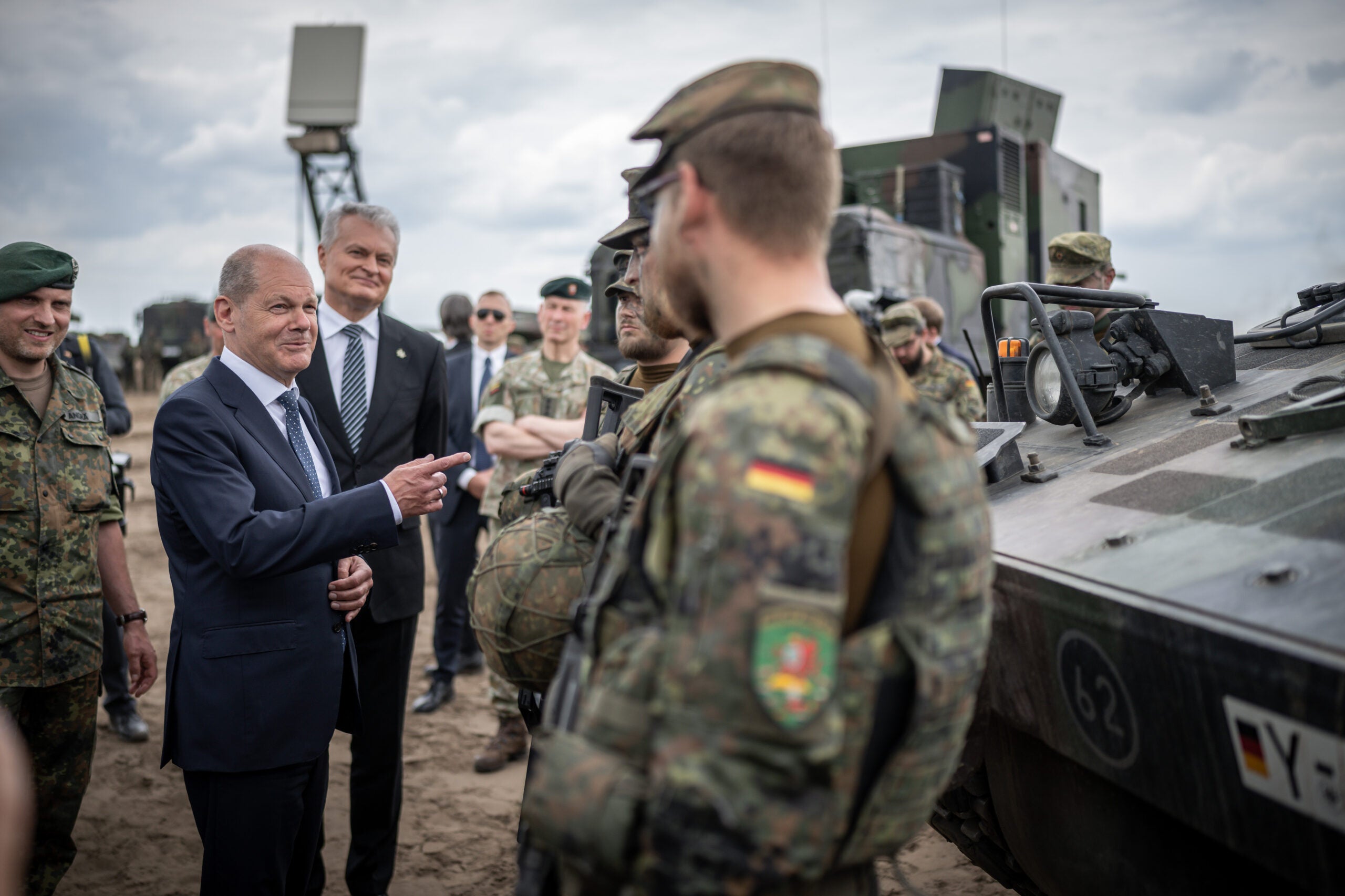 07 June 2022, Lithuania, Pabrade: German Chancellor Olaf Scholz (SPD, M), speaks with soldiers alongside Daniel Andrä, Bundeswehr commander of the NATO Enhanced Forward Presence Battle Group (eFP battalion, l) and Gitanas Nauseda, President of Lithuania (3rd from left), at Camp Adrian Rohn, where more than 1,000 Bundeswehr soldiers are stationed. Scholz has promised Lithuania additional military support to defend against a possible Russian attack. Photo: Michael Kappeler/dpa (Photo by Michael Kappeler/picture alliance via Getty Images)