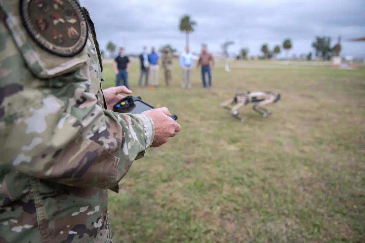 A member of the US Air Force uses a tablet-like decision to remotely operate a Ghost Robotics Vision 60 Q-UGV. <em>USAF/Airman 1st Class Tiffany Price</em>