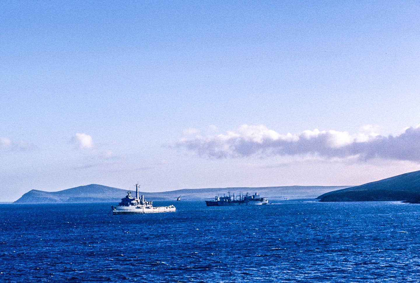 A Sea King operates from HMS <em>Intrepid</em> (nearest camera) in San Carlos Water in the Falkland Islands during the conflict. <em>Photo by Terence Laheney/Getty Images</em>