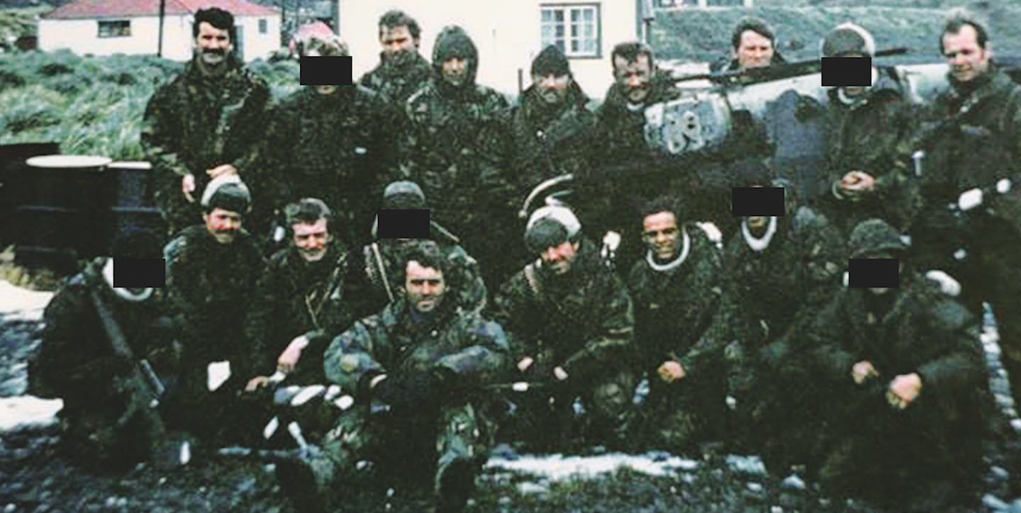 SAS Mountain Troop on South Georgia after its recapture on April 24, 1982. Six weeks later, six of those in the photo would be dead and three would have been evacuated due to injury. Splash is sitting in the middle of the front row. <em>Mark Aston</em>