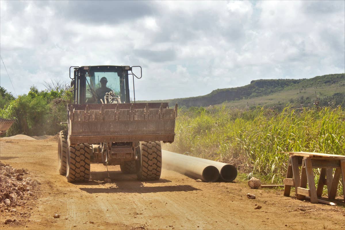 A U.S. Navy sailor assigned to Naval Mobile Construction Battalion 3 drives a front-end loader as part of a road construction project on Tinian as part Valiant Shield 22. <em>USN / Lt. Tyler Baldino</em>