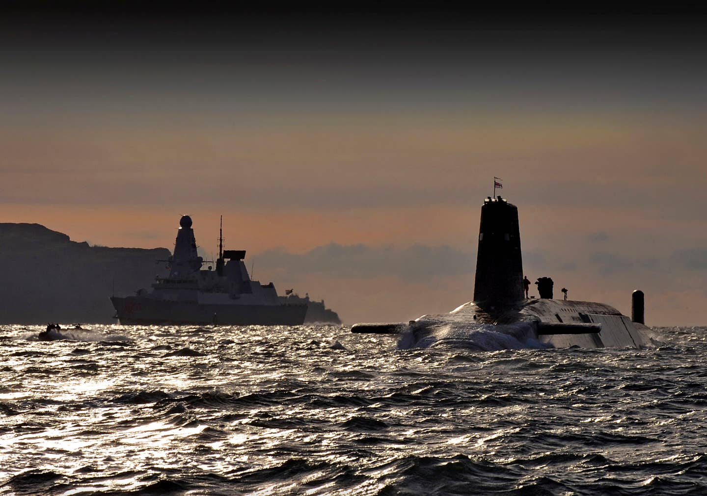 HMS <em>Vanguard</em> arrives back at HM Naval Base Clyde, Faslane, Scotland following a patrol. The Type 45 destroyer HMS <em>Dragon</em> can be seen in the background. <em>Crown Copyright</em>