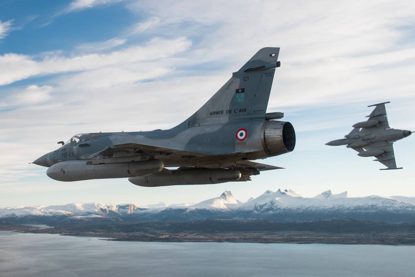 A Swedish Saab Gripen breaks from formation with a Mirage 2000C in Norwegian airspace during Exercise Trident Juncture 2018. <em>Jean-Luc Brunet / Armée de l'Air / Défense</em>