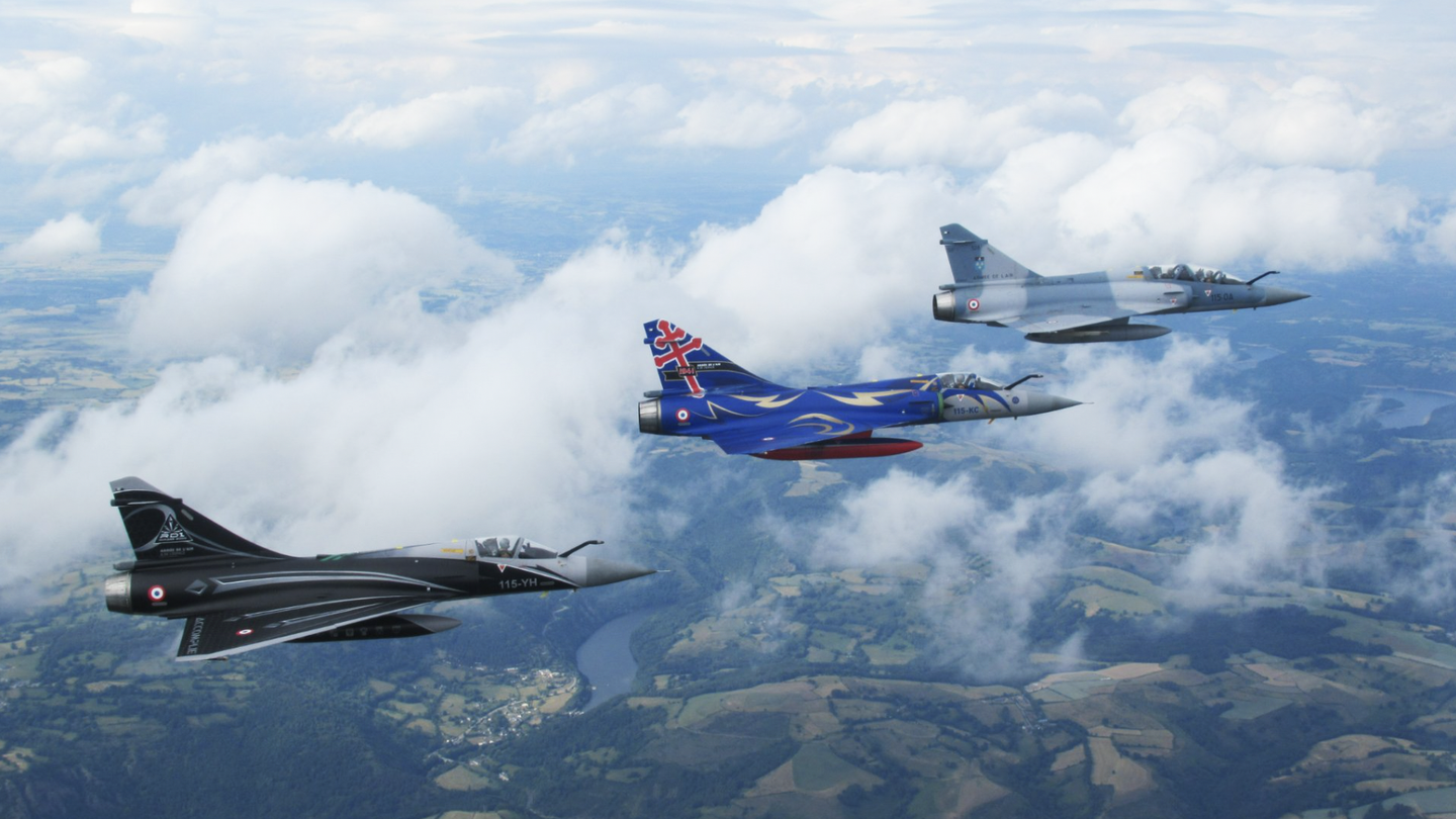 Two specially painted Mirage 2000Cs from EC 2/5 are led by a two-seat Mirage 2000B during the final air defense mission for the Mirage 2000C, over southeastern on June 9. <em>Armée de l’Air et de l’Espace</em>