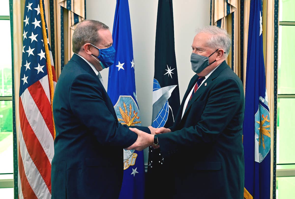 Assistant Secretary of the Air Force for Acquisition, Technology, and Logistics Andrew Hunter, at left, shakes hands with Secretary of the Air Force Frank Kendall, at right, during a meeting a the Pentagon in February 2022. <em>USAF / Wayne Clark</em>