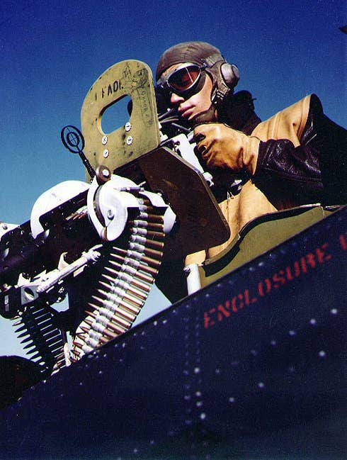 A radioman/gunner demonstrates the 30-caliber Browning machine guns in an SBD<em> </em>aboard the USS&nbsp;<em>Independence</em>. <em>U.S. Navy</em>