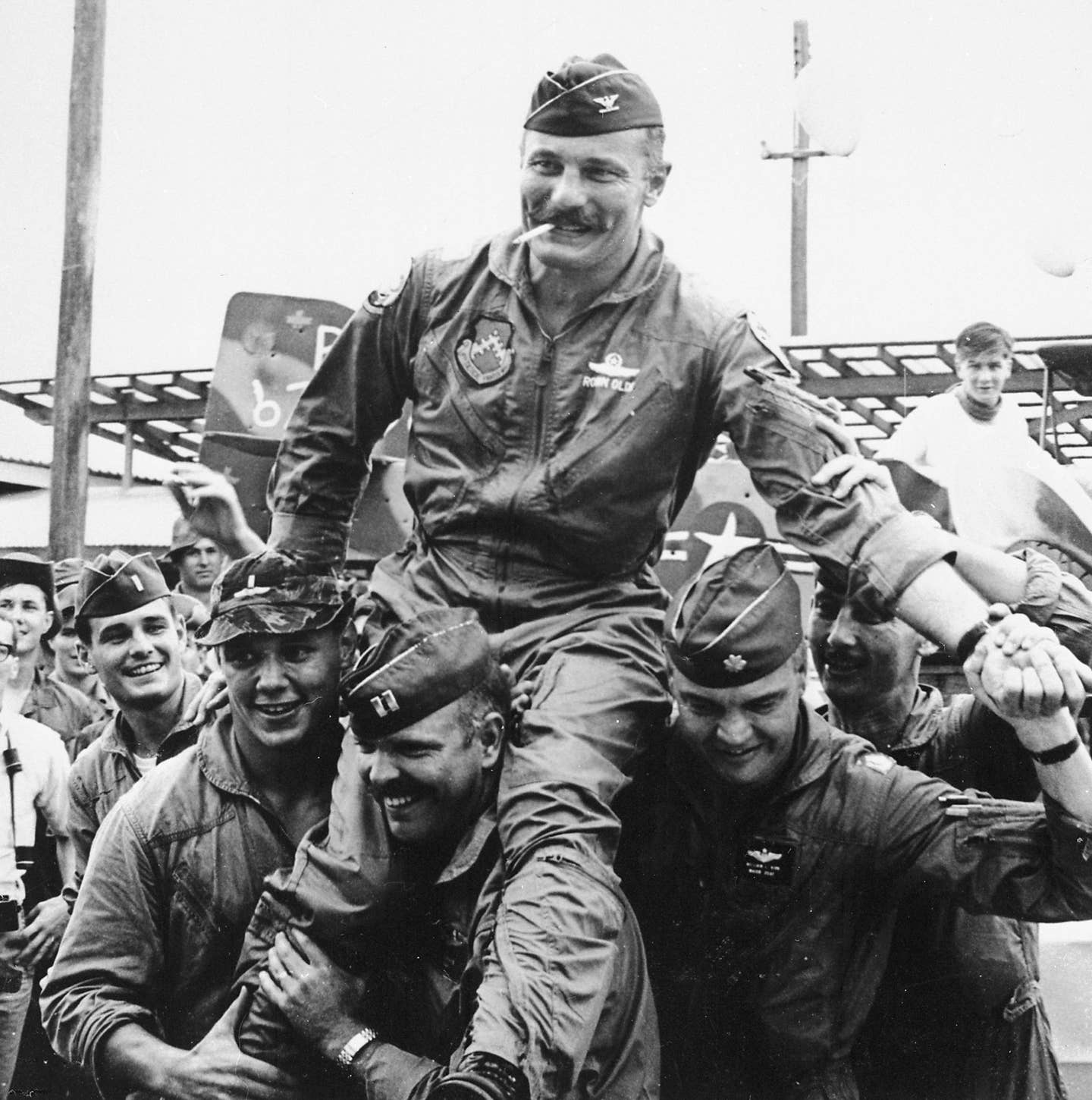 Members of the 8th Tactical Fighter Wing carry their commander, Col. Robin Olds, following his return from his last combat mission over North Vietnam, on September 23, 1967. <em>U.S. Air Force</em><br><a href="https://www.nationalmuseum.af.mil/Visit/Museum-Exhibits/Fact-Sheets/Display/Article/196007/brig-gen-robin-olds-combat-leader-and-fighter-ace/undefined"></a>
