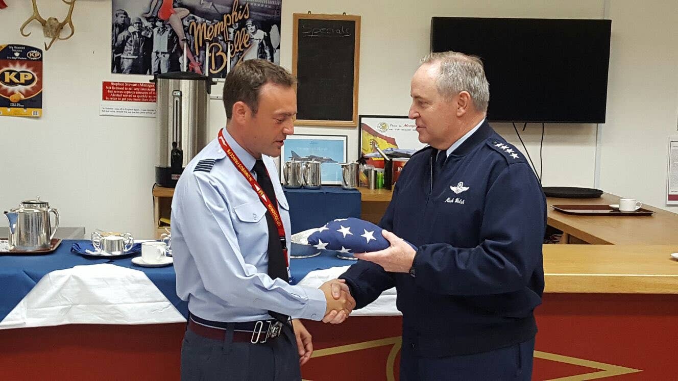 Gen. Mark A. Welsh III, then the Chief of Staff of the U.S. Air Force, hands over a Stars and Stripes to Wg. Cdr. Mike Sutton in the Robin Olds Bar. <em>Mike Sutton</em>