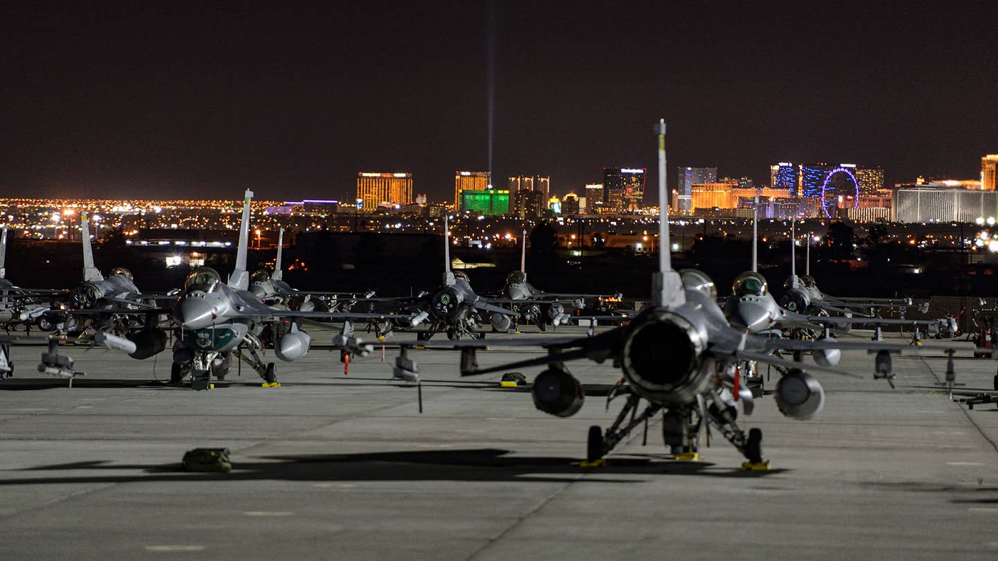 The F-16 flight line during a Red Flag, with the Las Vegas Strip in the distance. <em>Jamie Hunter</em>