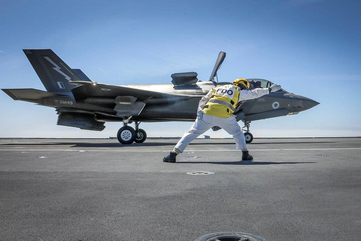 The Flight Deck Officer onboard the aircraft carrier HMS <em>Prince of Wales</em> launches a Royal Air Force F-35B. <em>Crown Copyright</em>
