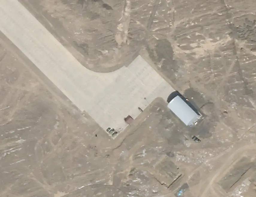 Vehicles, along with what appears to be a small shelter, on the main ramp at the air base near Lop Nor on September 8, 2020, after the previous spaceplane test. <em>PHOTO © 2022 PLANET LABS INC. ALL RIGHTS RESERVED. REPRINTED BY PERMISSION</em>