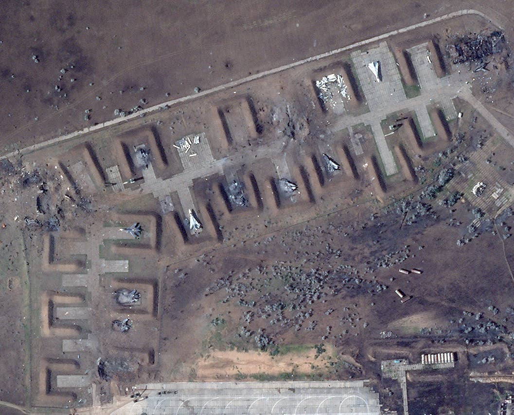 A close-up of the damage to the revetment area. One of the destroyed structures was situated at the bend in the taxiway, where there is now a crater visible in this image, while what's left of the other one, along with a nearby burned-out Su-24, can be seen at the top right corner. <em>PHOTO © 2022 PLANET LABS INC. ALL RIGHTS RESERVED. REPRINTED BY PERMISSION</em>