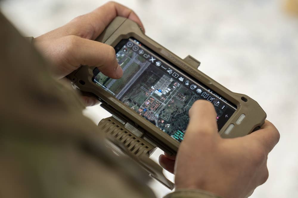 A cell phone linked to the AERONet system displays the real-time locations of personnel, vehicles, and aircraft during an exercise outside of Rionegro, Colombia, in September 2021. <em>U.S. Air Force photo by Tech. Sgt. Kenneth New</em>