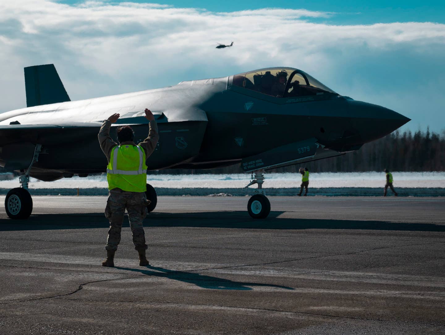 A U.S. Airman marshals a formation of 42 F-35A Lightning IIs during a routine readiness exercise at Eielson Air Force Base, Alaska, March 25, 2022. This capabilities demonstration represented the culmination of the dedicated efforts of the 354th Fighter Wing, with each Airman providing vital contributions to ensure Team Eielson’s readiness to deliver airpower anytime, anywhere. (U.S. Air Force photo by Airman 1st Class Elizabeth Schoubroek)
