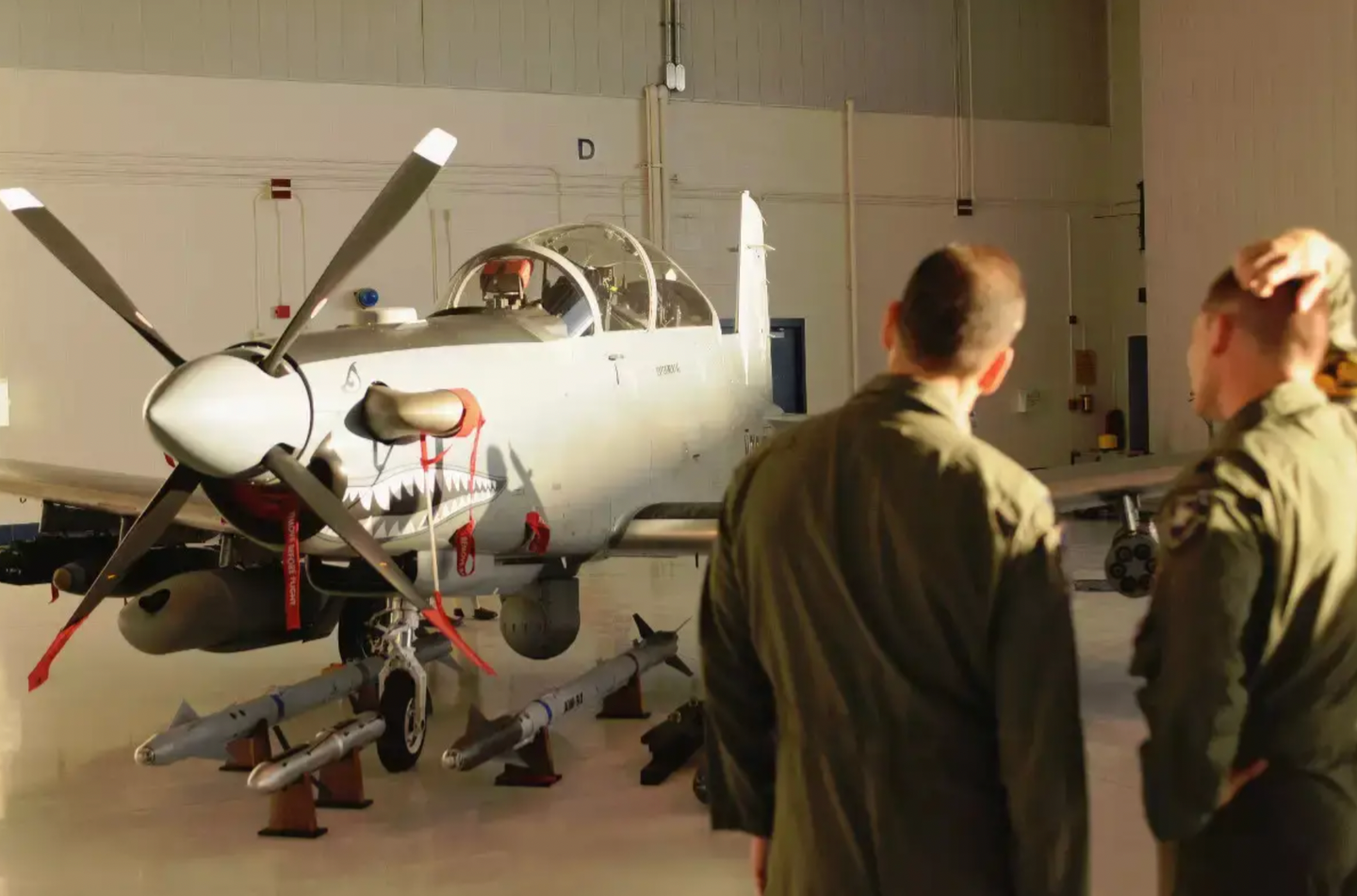 Members of the Air National Guard look at an example of what was then known as the AT-6C during tests in 2010. Interestingly two AIM-9X air-to-air missiles are among the ordnance laid out in front of the aircraft.&nbsp;<em>USAF</em>