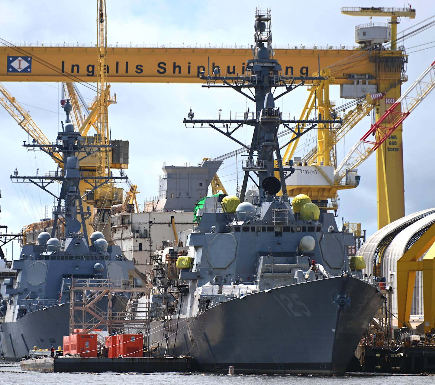 The future USS <em>Jack H. Lucas</em> being fitted out at the Ingalls Shipbuilding yard in Pascagoula, Mississippi on August 4, 2022. The future USS&nbsp;<em>Lenah H. Sutcliffe Higbee</em>, a Flight IIA <em>Arleigh Burke</em> class destroyer, is right behind <em>Jack H. Lucas</em>, offering a good comparison between the fixed-face antennas for the new AN/SPY-6(V)1 radar and those for the older AN/SPY-1D fitted to earlier ships of this class. The future USS <em>Bougainville</em>, a subvariant of the America class amphibious assault ship, can also be seen under construction behind the two destroyers. <em>Chris Cavas photo</em>&nbsp;