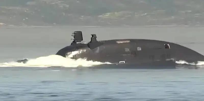 A screengrab from an RT broadcast showing the sail of a Russian Navy <em>Akula II</em> class submarine. The fairing on the right side of the sail has been identified as being associated with the boat's <em>System Obnarujenia Kilvaternovo Sleda</em>&nbsp;(SOKS), or Wake Object Detection System, and has some general similarities to the ones seen on the Surrogat-V model. <em>RT capture</em>