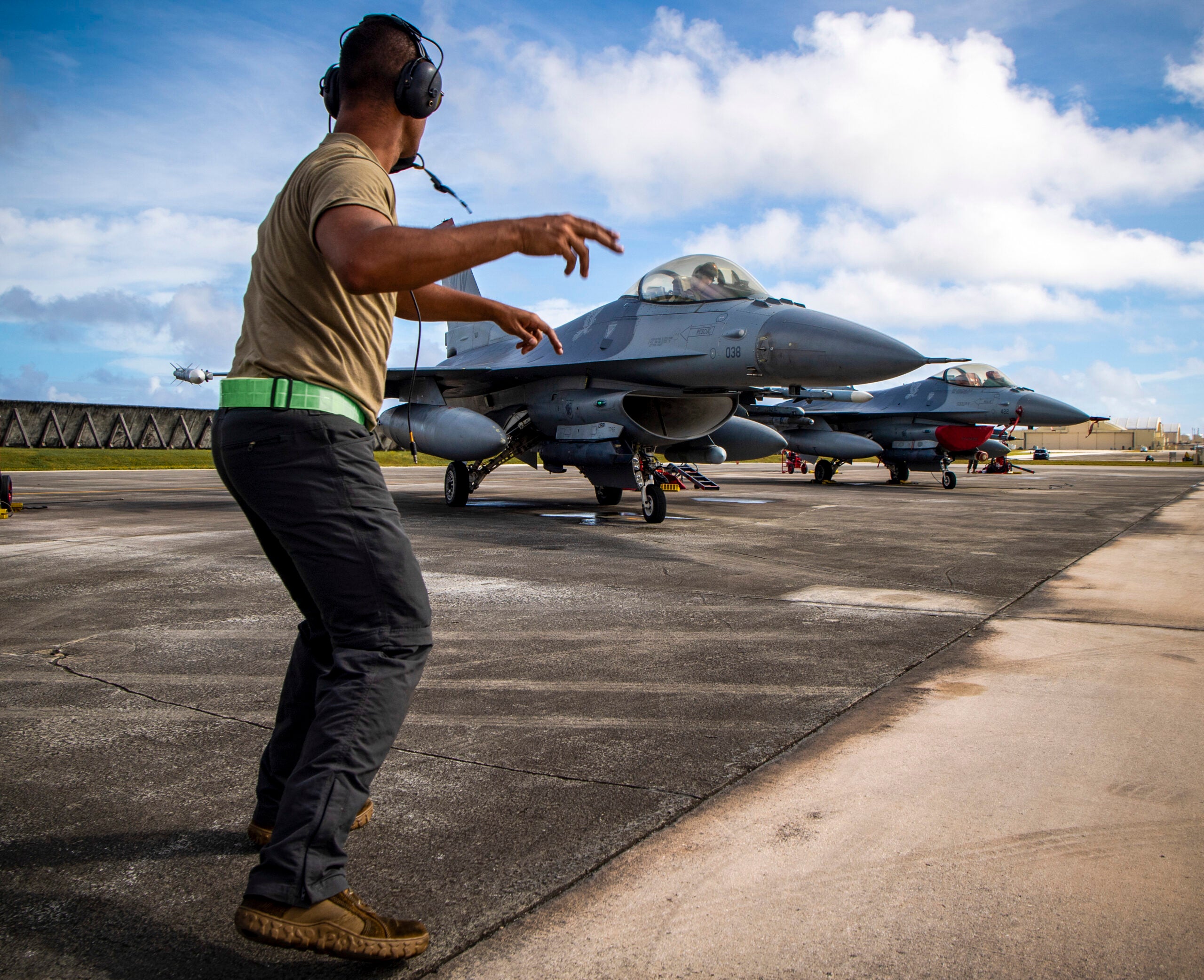 A U.S. Air Force crew chief assigned to the 13th Aircraft Maintenance Squadron motions a U.S. Air Force F-16 Fighting Falcon assigned to the 13th Fighter Squadron to taxi during exercise Cope North 21 at Andersen Air Force Base, Guam, Feb. 17, 2021.   Exercises such as Cope North allow the Pacific Air Forces to validate new ways to deploy and maneuver assets through exercises and engagements. (U.S. Air Force photo by Senior Airman Duncan C. Bevan)