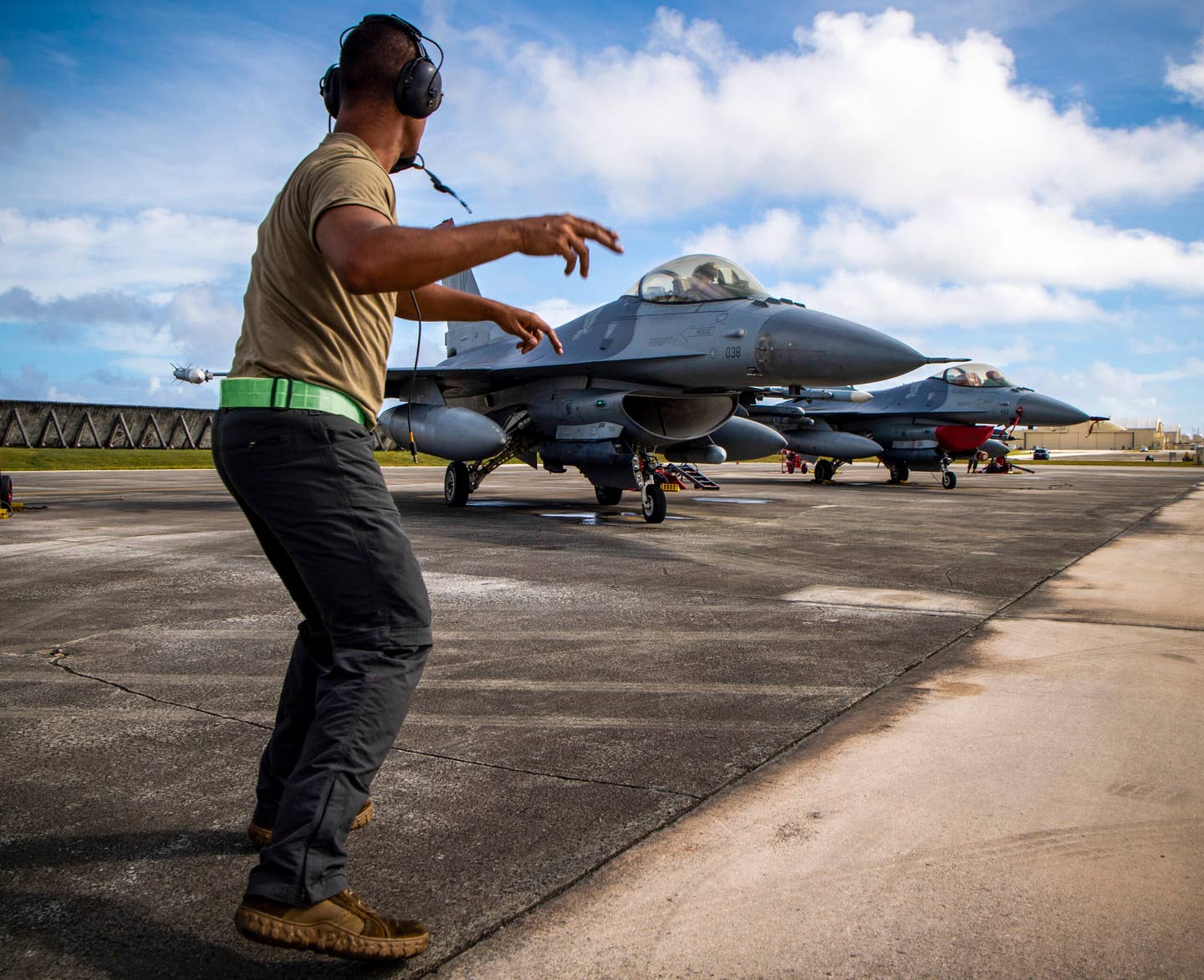A U.S. Air Force crew chief assigned to the 13th Aircraft Maintenance Squadron motions a U.S. Air Force F-16 Fighting Falcon assigned to the 13th Fighter Squadron to taxi during exercise Cope North 21 at Andersen Air Force Base, Guam, Feb. 17, 2021.  (U.S. Air Force photo by Senior Airman Duncan C. Bevan)