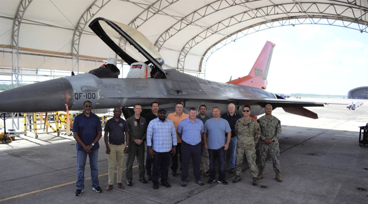 Individuals from the Defense Contract Management Agency's Aircraft Integrated Maintenance Operations-St. Augustine stand in front of the last QF-16 to be converted at Boeing's facility at Cecil Airport in Jacksonville, Florida. <em>Boeing</em>