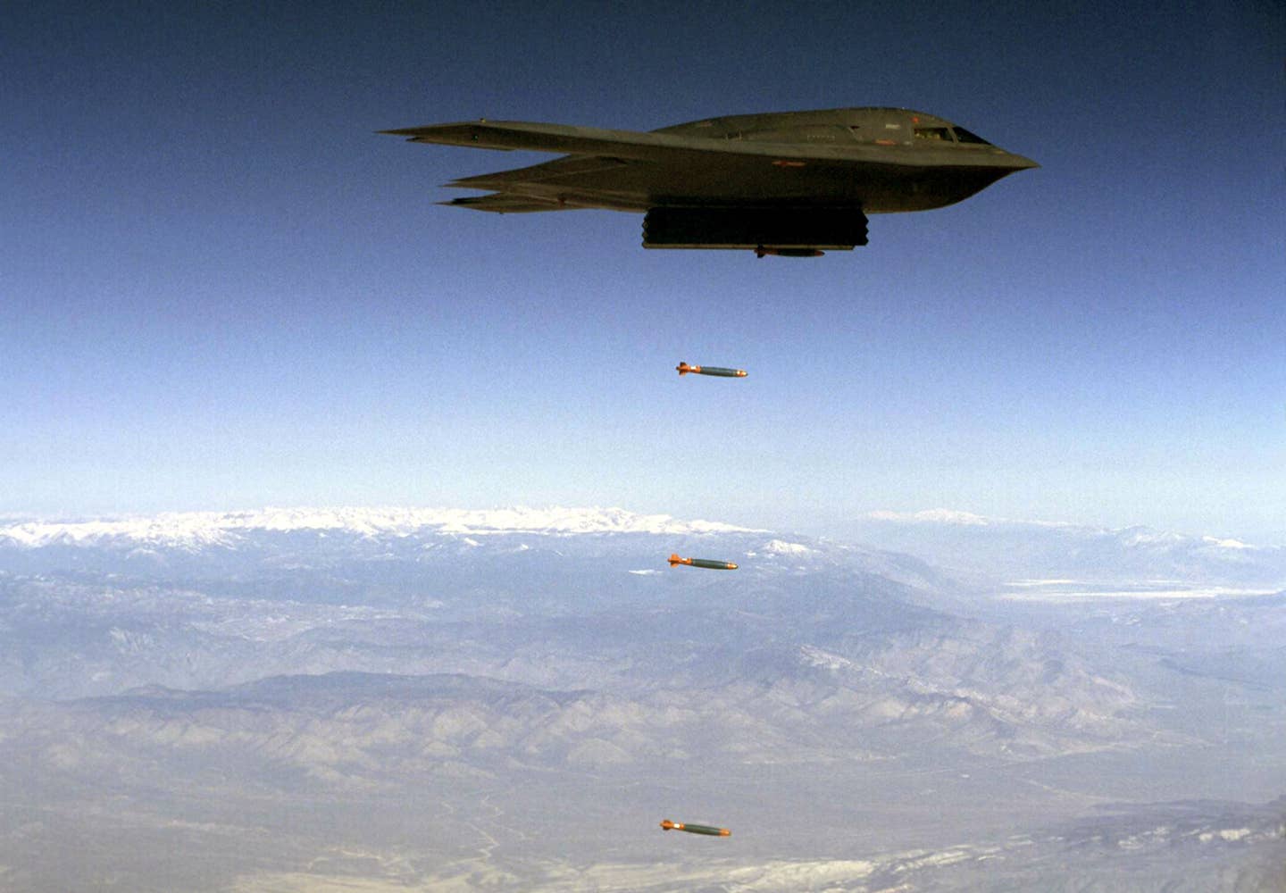 A B-2 drops Joint Direct Attack Munition (JDAM) separation test vehicles over Edwards Air Force Base, California. <em>U.S. Air Force</em>