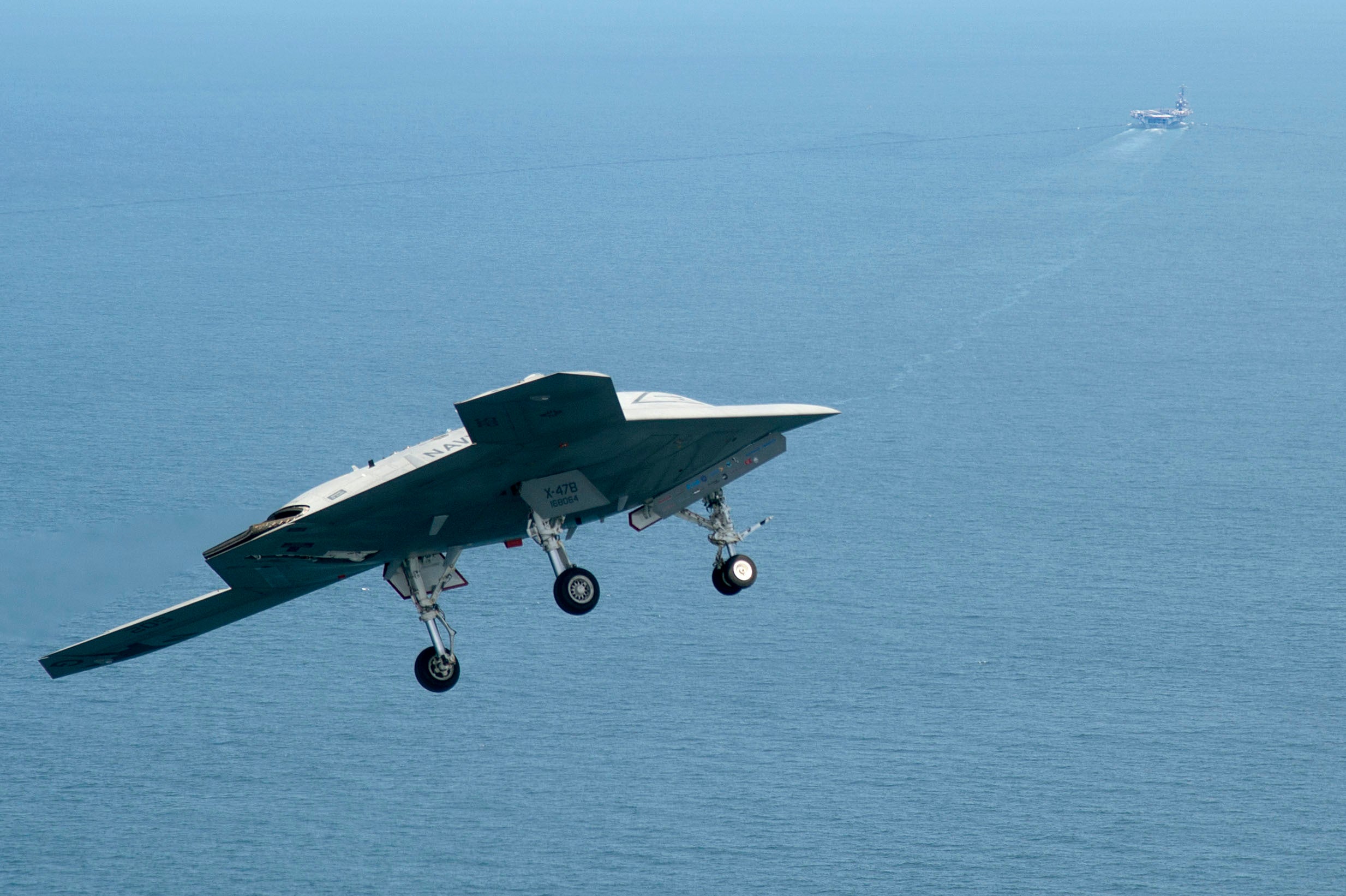 An X-47B Unmanned Combat Air System demonstrator flies near the aircraft carrier USS George H.W. Bush (CVN 77). George H.W. Bush is the first aircraft carrier to successfully catapult launch an unmanned aircraft from its flight deck. (U.S. Navy photo by Erik Hildebrandt/Released)