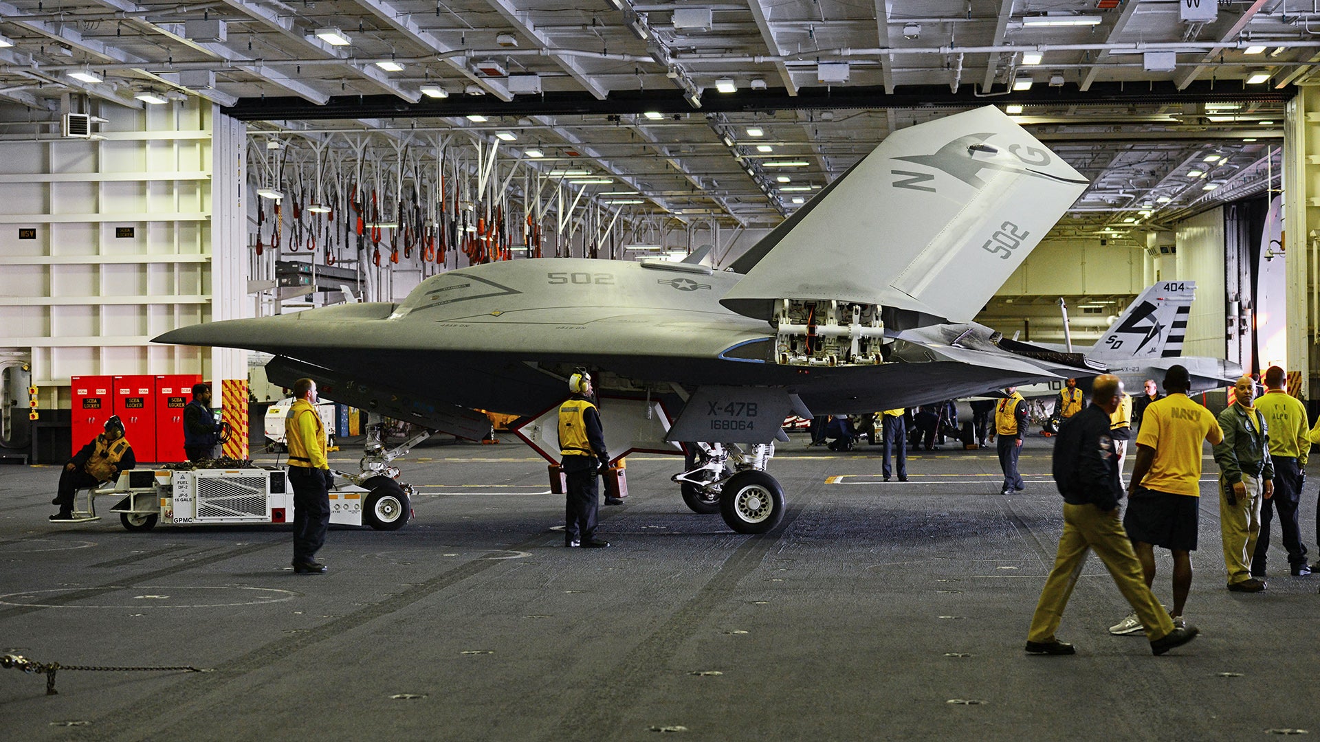 130514-N-TB177-025
ATLANTIC OCEAN (May 14, 2013) An X-47B Unmanned Combat Air System (UCAS) demonstrator aircraft is transported in the hangar bay of the aircraft carrier USS George H.W. Bush (CVN 77). George H.W. Bush is conducting training operations in the Atlantic Ocean. (U.S. Navy photo by Mass Communication Specialist 3rd Class Kevin J. Steinberg/Released)