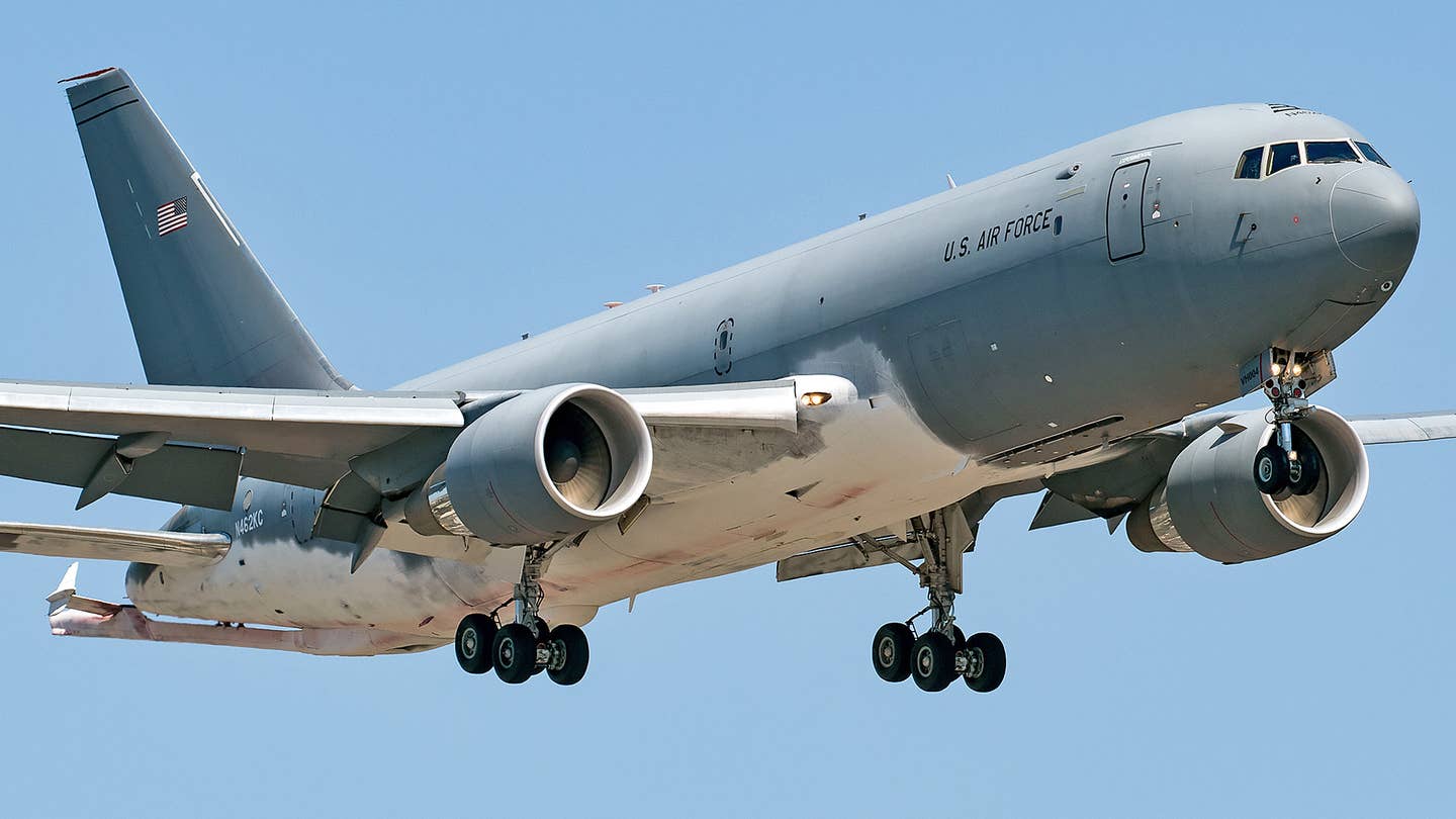A Boeing KC-46A aerial refueling tanker recently seen with areas of the underside of its fuselage, wings, and rear stabilizers covered with some kind of white coating.