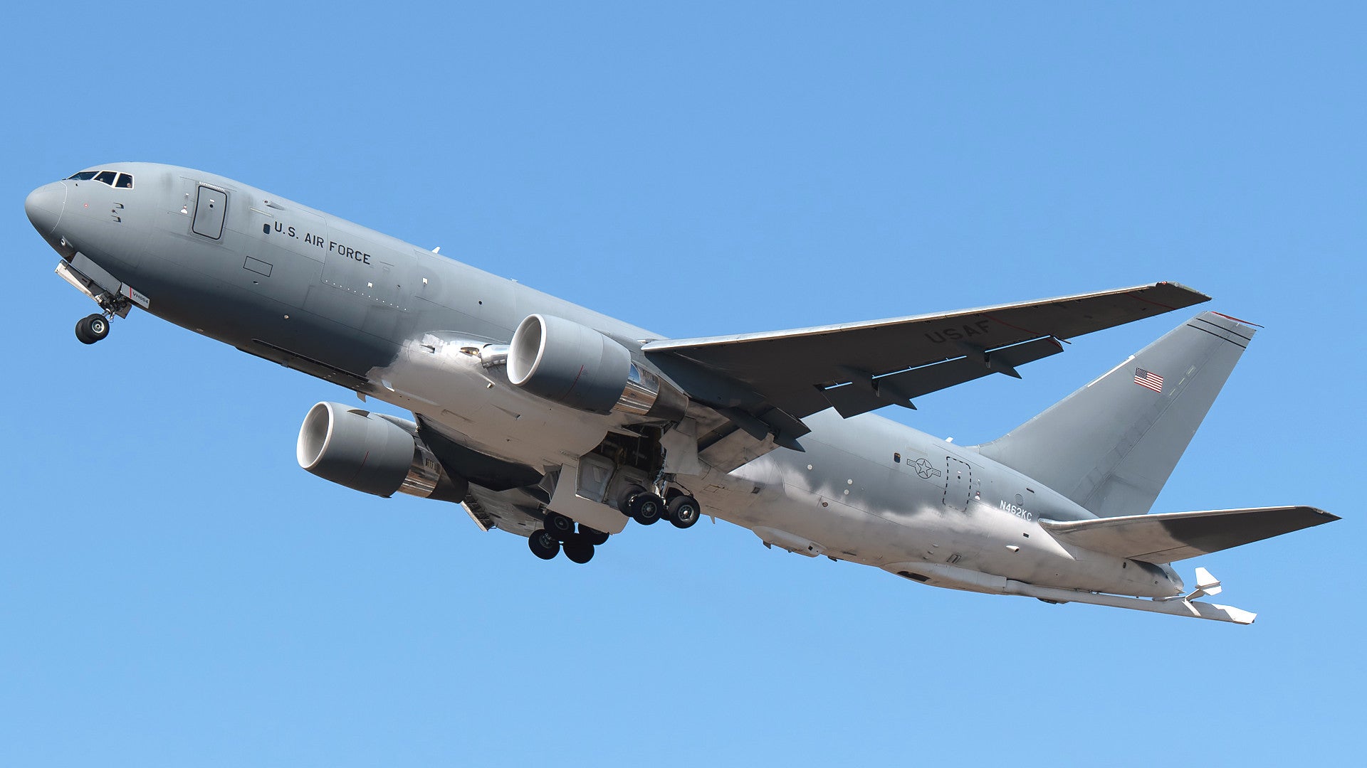 A Boeing KC-46A aerial refueling tanker with areas of the underside of its fuselage, wings, and rear stabilizers covered with some kind of white coating.