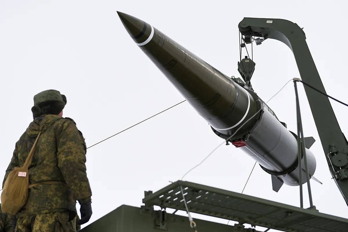 A Russian soldier observes the loading of a 9K720 Iskander-M short-range ballistic missile. <em>Russian Ministry of Defense</em>
