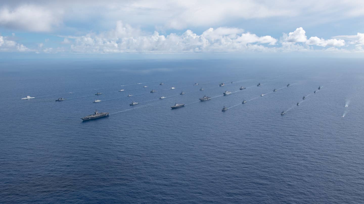 Ships sail in formation during Rim of the Pacific (RIMPAC) 2022. A line of unmanned vessels can be seen off to the far left led by <em>USS Michael Monsoor.</em> <em>Credit: Mass Communication Specialist 3rd Class Dylan Lavin/U.S. Navy </em>