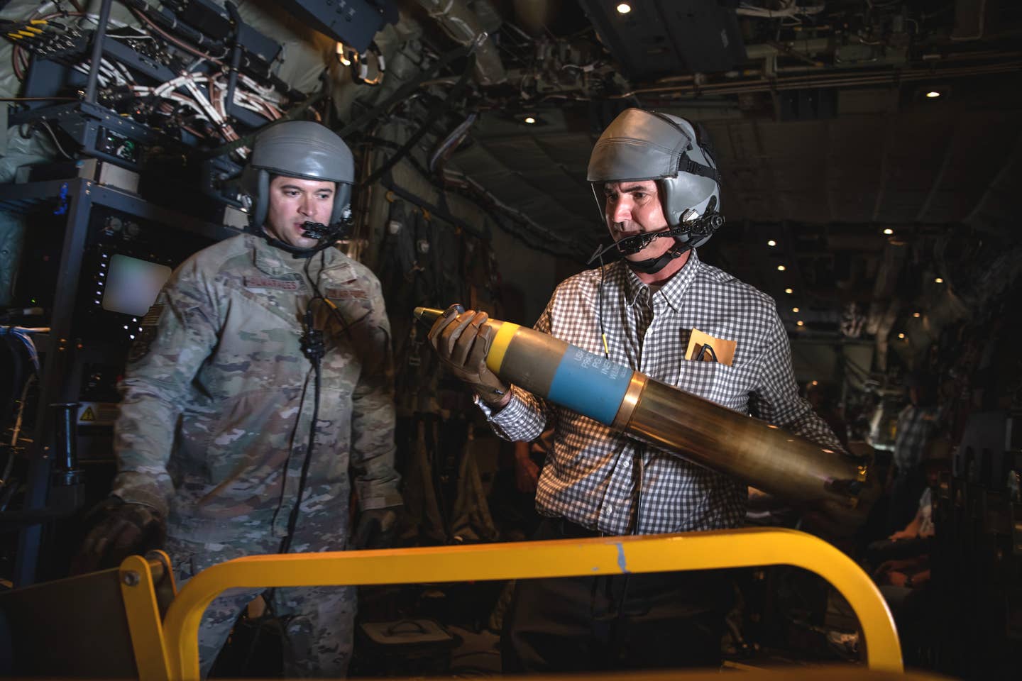 One of the 'honorary commanders' prepares to load a 105mm practice round into the howitzer onboard the AC-130J during the community engagement event at Cannon on August 24.  <em>U.S. Air Force photo.</em>
