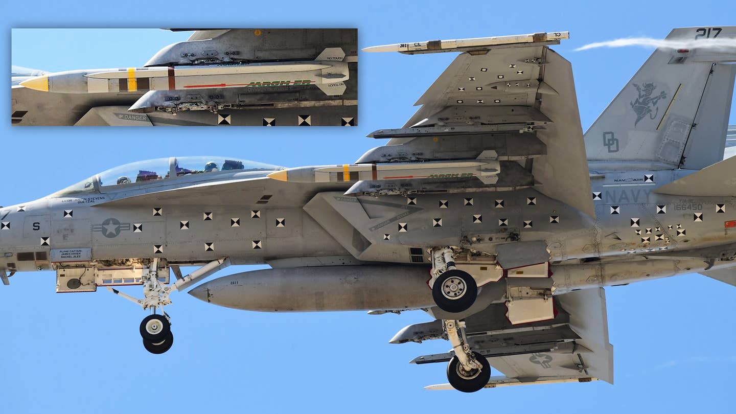 A US Navy F/A-18F Super Hornet carrying a live AGM-88G AARGM-ER missile, with an inset showing a close-up of the missile from a different angle.