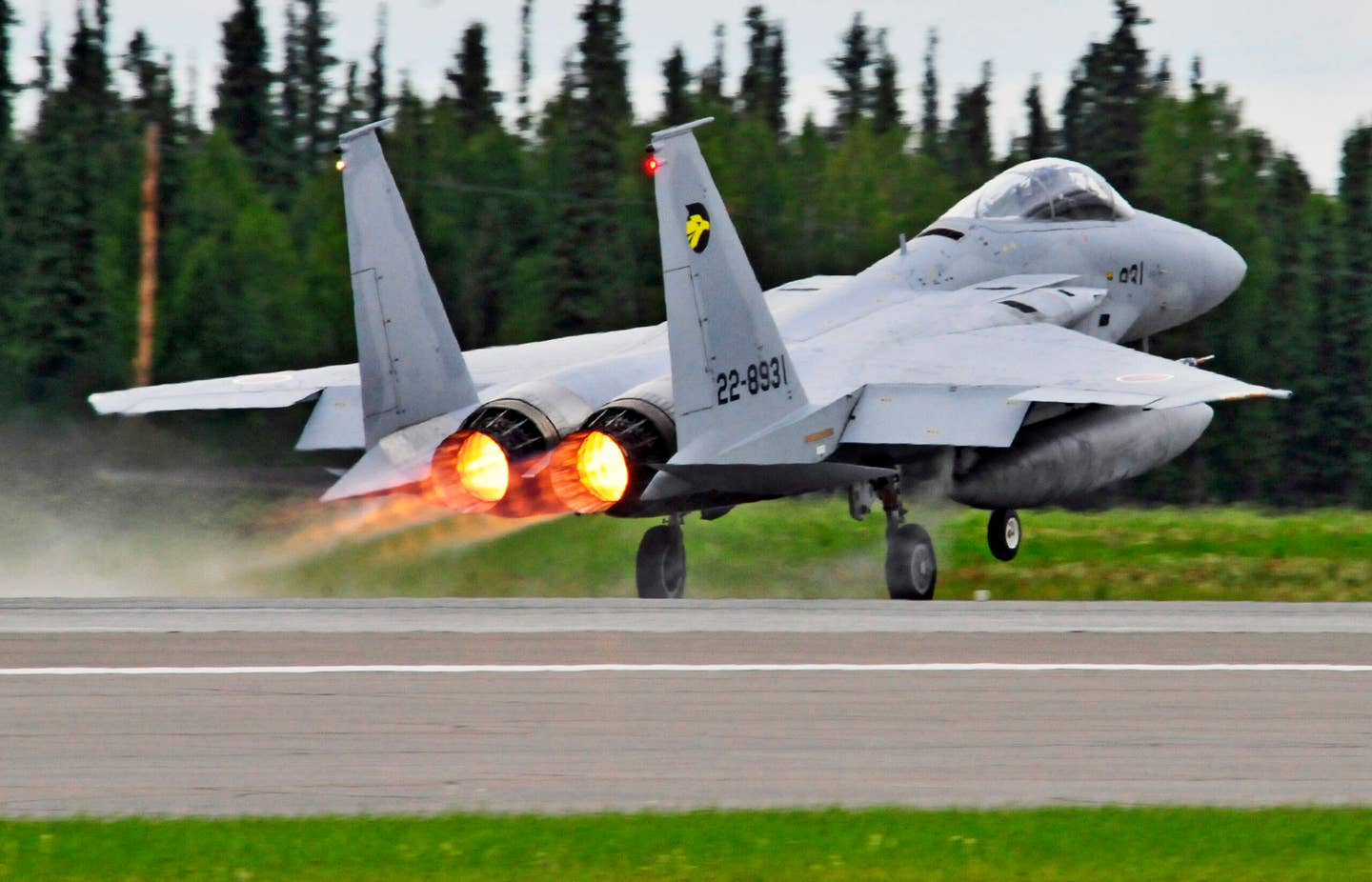 A JASDF F-15J wearing the golden eagle markings of 306 Hikotai launches from the runway during Red Flag-Alaska at Eielson Air Force Base, Alaska. <em>U.S. Air Force photo by/Staff Sgt. Miguel Lara</em>