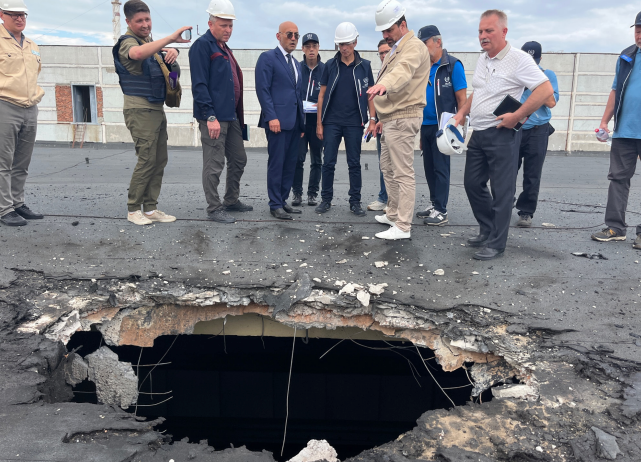 The IAEA team observes the damage caused by shelling on the roof of the special building at the ZNPP that houses, among other items, the fresh nuclear fuel and the solid radioactive waste storage facility. (Photo: IAEA)