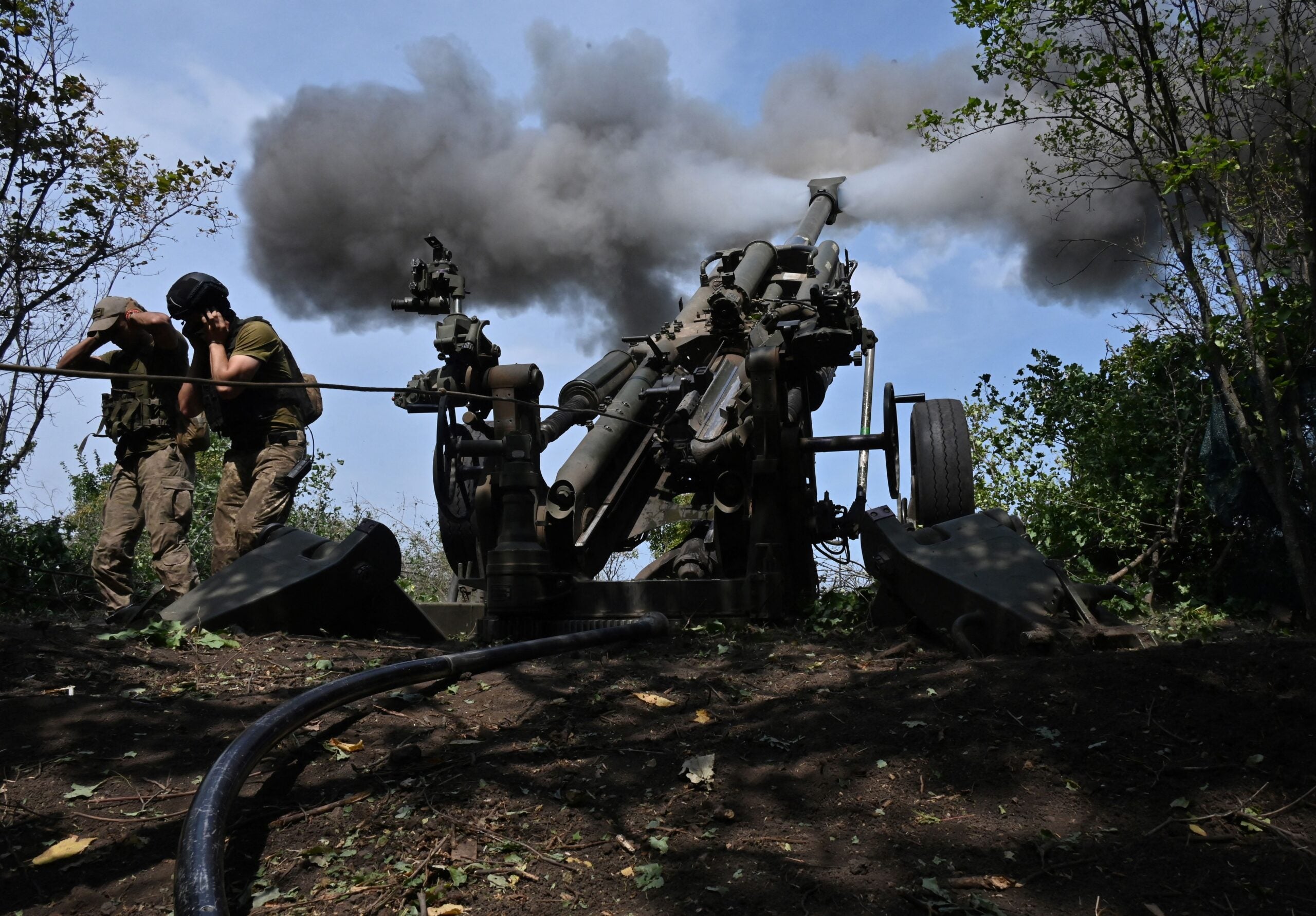 Ukrainian gunmen fire a US made M777 howitzer from their position on the front line in Kharkiv region on August 1, 2022, amid Russia's military invasion launched on Ukraine. (Photo by SERGEY BOBOK / AFP) (Photo by SERGEY BOBOK/AFP via Getty Images)