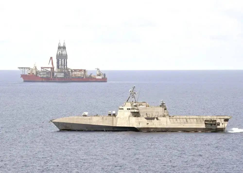 The US Navy's <em>Independence</em> class littoral combat ship USS <em>Gabrielle Giffords</em>, in the foreground, sails past the drillship <em>West Capella</em>, operating under contract to the Malaysian government, in the South China Sea in May 2020. <em>West Capella</em> was at the center of a dispute between Malaysia and China at the time. This reflects exactly the kind of non-combat efforts to help "disrupt malign activities" that the 2020 tri-service naval strategy highlighted as being an important task for U.S. forces going foward. <em>USN</em>