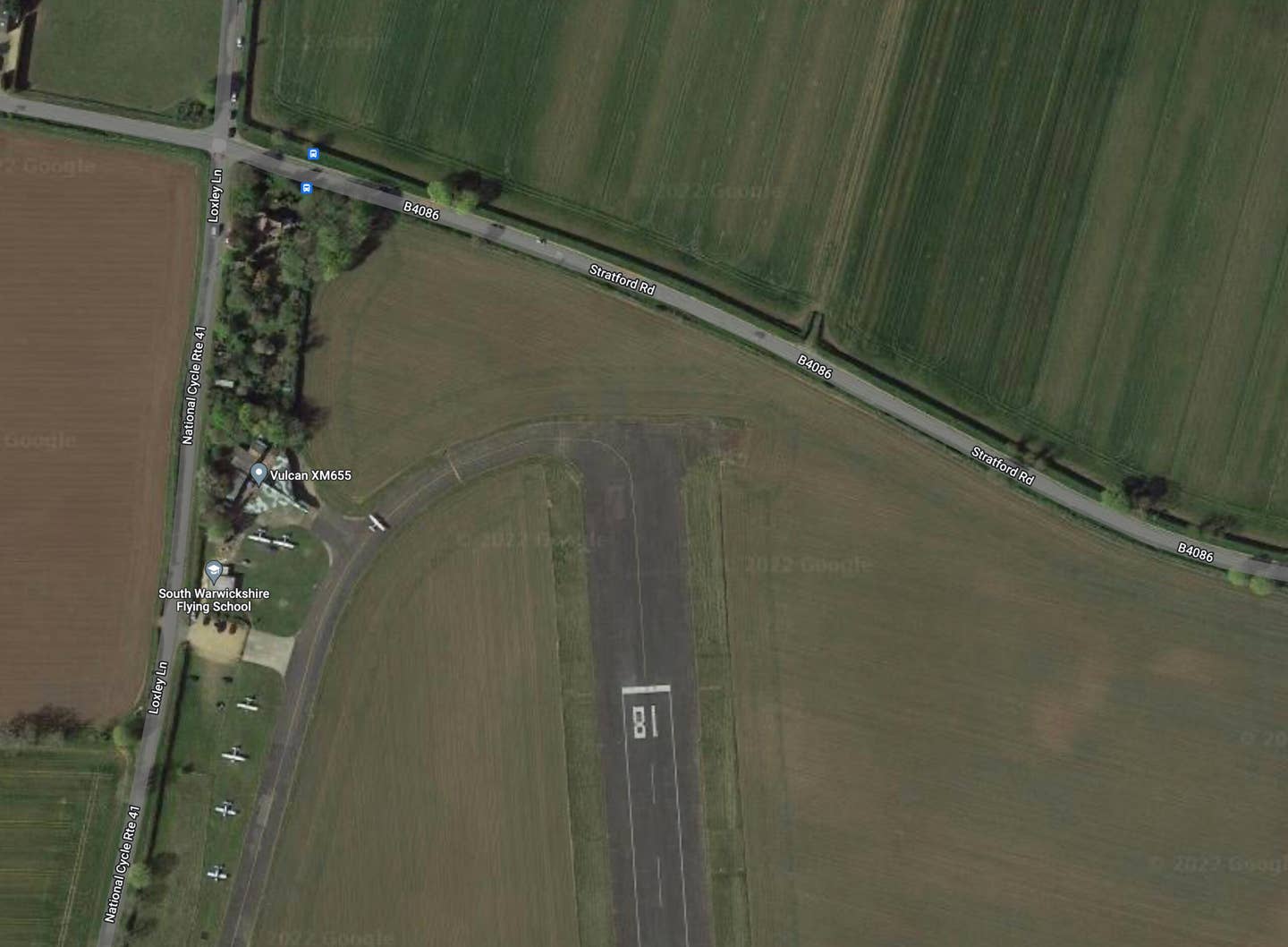 Satellite imagery illustrating the small strip of land separating Wellesbourne Mountford Airfield's main runway with the B4086. <em>Google Earth. </em>